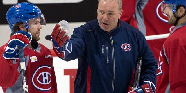 Montreal Canadiens head coach Michel Therrien goes over a play with Montreal Canadiens center David Desharnais, left, and left wing Max Pacioretty, right, during the team's NHL hockey practice Monday, April 28, 2014, in Brossard, Quebec. (AP Photo/The Canadian Press, Ryan Remiorz)