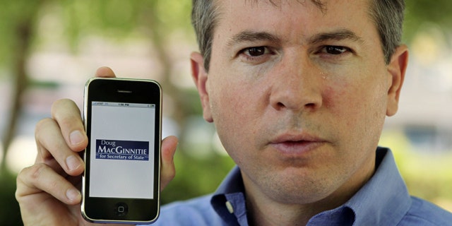Candidate for Georgia Secretary of State Doug MacGinnitie poses with his iPhone in Atlanta. MacGinnitie had a friend created an iPhone applications so supporters can follow his campaign and make contributions.