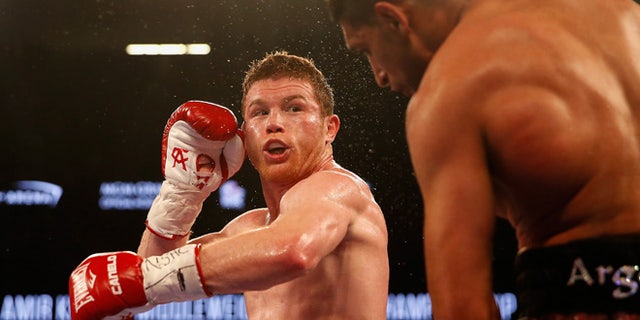 LAS VEGAS, NEVADA - MAY 07:  Canelo Alvarez (L) throws a left at Amir Khan during the WBC middleweight title fight at T-Mobile Arena on May 7, 2016 in Las Vegas, Nevada.  (Photo by Christian Petersen/Getty Images)