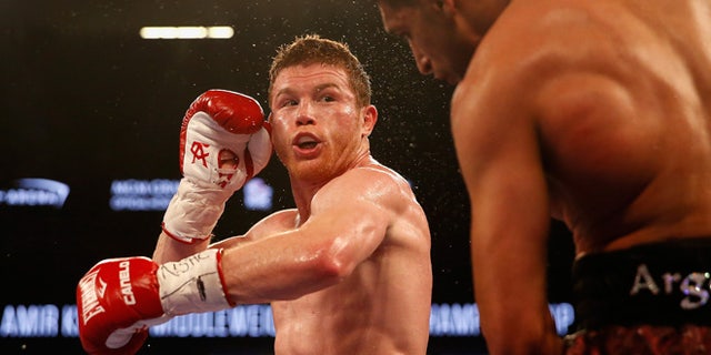 LAS VEGAS, NEVADA - MAY 07: Canelo Alvarez (L) throws a left at Amir Khan during the WBC middleweight title fight at T-Mobile Arena on May 7, 2016 in Las Vegas, Nevada. (Photo by Christian Petersen/Getty Images)