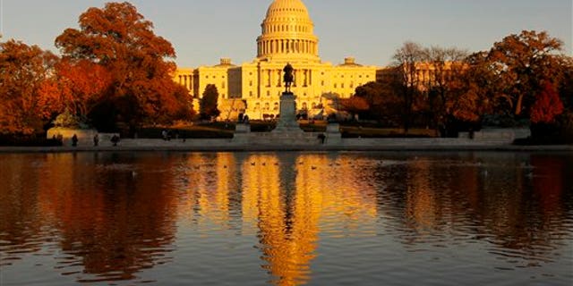 The US Capitol is bathed in the setting sun and seen in the reflecting pool on Capitol Hill in Washington, Friday, Nov. 12, 2010. Congress returns next week for a post-election lame duck session. (AP Photo/Alex Brandon)