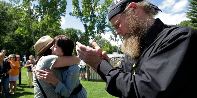 June 22, 2013: Bob Bergdahl, right, and wife, Jani, center, the parents of captive U.S. Army Sgt. Bowe Bergdahl, are comforted by a supporter at the 'Bring Bowe Back' celebration held to honor Sgt. Bergdahl in Hailey, Idaho.