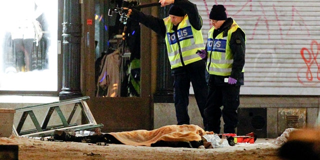 Police forensics experts examine the scene in Stockholm after an apparent suicide attack