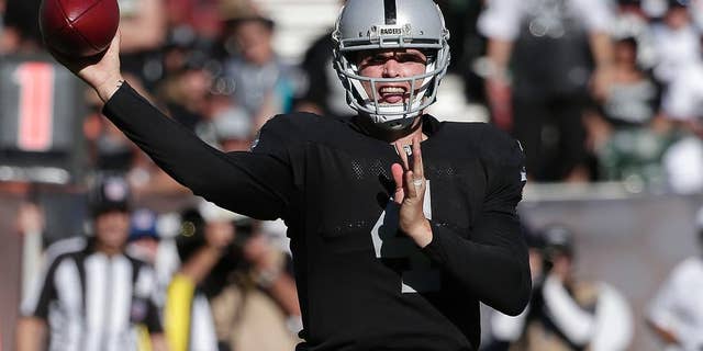Oakland Raiders quarterback Derek Carr (4) passes against the Arizona Cardinals during the second half of an NFL football game in Oakland, Calif., Sunday, Oct. 19, 2014. The Cardinals won 24-13. (AP Photo/Marcio Jose Sanchez)