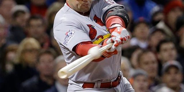 FILE - In this Oct. 24, 2013, file photo, St. Louis Cardinals' Carlos Beltran hits an RBI single during Game 2 of baseball's World Series against the Boston Red Sox in Boston. Two people familiar with the negotiations say outfielder Carlos Beltran and the New York Yankees have agreed to a $45 million, three-year contract. (AP Photo/David J. Phillip, File)