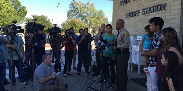 Carlos Rodriguez, in the green shirt, is awarded a certificate by the Los Angeles County Sheriff's Department.