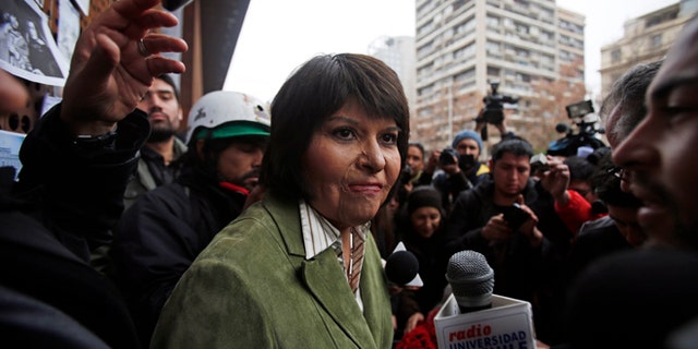 Carmen Quintana attends a tribute for slain photographer Rodrigo Rojas, outside the Gabriela Mistral museum, in Santiago, Chile, Tuesday, July 28, 2015. During a street demonstration on July 2, 1986, soldiers doused Rojas and then 18-year-old Quintana with gasoline and set them ablaze. Rojas died four days later. Quintana survived and underwent lengthy treatment for severe burns at a Canadian hospital. Her scarred face later became a symbol of the atrocities committed by Pinochet's dictatorship. A Chilean judge last week charged seven former members of the military in the burning death of Rojas, and four other ex-soldiers were being questioned on Monday. (AP Photo/Luis Hidalgo)