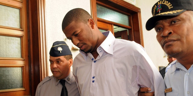 Cleveland Indians pitcher Fausto Carmona, whose real name is Roberto Hernandez Heredia, center, is escorted by police out of court in Santo Domingo, Dominican Republic, Friday Jan. 20, 2012. Hernandez made a tearful apology as he was released on bail following his arrest on Thursday outside the U.S. Consulate in the Dominican capital as he went to get his visa renewed, for allegedly using a false identity to play baseball in the U.S. He is the second Dominican player arrested in recent weeks for using a false identity. (AP Photo/Manuel Diaz)