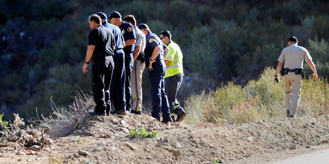 California Highway patrol officers investigate the scene of two cars that were recovered at the bottom of a remote mountain in Castaic, Calif., Friday, Sept. 30, 2011 .