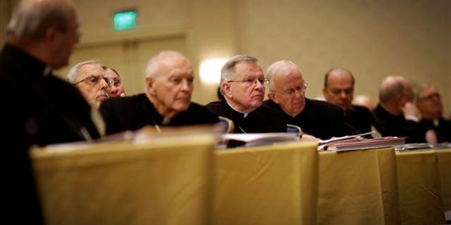 Archbishop Gregory Aymond of New Orleans, center, listens to a report as he sits with fellow bishops at the United States Conference of Catholic Bishops' annual fall meeting in Baltimore, Monday, Nov. 11, 2013, their first national meeting since Pope Francis was elected. (AP Photo/Patrick Semansky)
