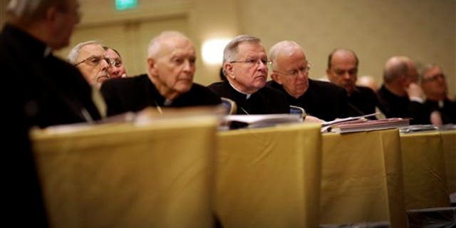 Archbishop Gregory Aymond of New Orleans, center, listens to a report as he sits with fellow bishops at the United States Conference of Catholic Bishops' annual fall meeting in Baltimore, Monday, Nov. 11, 2013, their first national meeting since Pope Francis was elected. (AP Photo/Patrick Semansky)