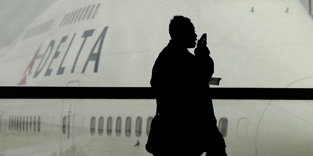 A traveler on Delta Airlines waits for her flight in Detroit. As federal regulators consider removing a decades-old prohibition on making phone calls on planes, a majority of air travelers oppose such a change, a recent poll found.