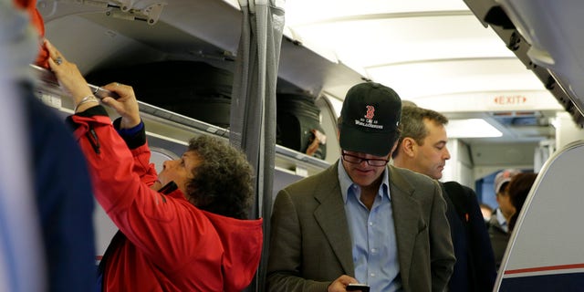 Oct. 31, 2013: A passenger checks his cell phone while boarding a flight in Boston.