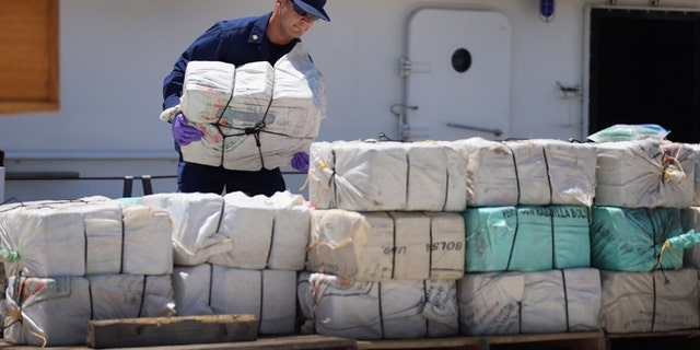 MIAMI, FL - APRIL 26:  A crew member from the Coast Guard Cutter Bernard C. Webber piles up some of the 2,200 pounds of cocaine after it was seized during Operation Martillo, worth an estimated $27 million on April 26, 2013 in Miami, Florida. The cocaine was found while the crew was conducting a law enforcement patrol, where they located a 68-foot fishing vessel in the western Caribbean Sea, April 18, 2013. The crew of the Cutter Gallatin boarded the vessel, located 2,200 pounds of cocaine, and detained three suspected smugglers.  (Photo by Joe Raedle/Getty Images)