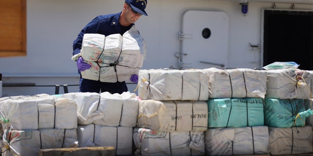 MIAMI, FL - APRIL 26: A crew member from the Coast Guard Cutter Bernard C. Webber piles up some of the 2,200 pounds of cocaine after it was seized during Operation Martillo, worth an estimated $27 million on April 26, 2013 in Miami, Florida. The cocaine was found while the crew was conducting a law enforcement patrol, where they located a 68-foot fishing vessel in the western Caribbean Sea, April 18, 2013. The crew of the Cutter Gallatin boarded the vessel, located 2,200 pounds of cocaine, and detained three suspected smugglers. (Photo by Joe Raedle/Getty Images)