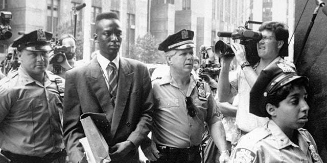 FILE - This 1990 file photo provided by Sundance Selects shows accused rapist Yusef Salaam, second right, being escorted by police in New York in 1990. Salaam is the subject of the documentary, "The Central Park Five," about the 1989 case of five black and Latino teenagers who were convicted of raping a white woman in Central Park. A city official said Friday, June 20, 2014 that New York City has agreed to a $40 million settlement in a civil rights lawsuit filed against police and prosecutors by Salaam and four co-defendants exonerated in the notorious case of a jogger attacked in Central Park in 1989. (AP Photo/Sundance Selects, NY Daily News, File)