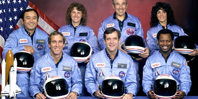 An official portrait shows the STS-51L crewmembers. Back row (L to R): Mission Specialist, Ellison S. Onizuka, Teacher in Space Participant Sharon Christa McAuliffe, Payload Specialist, Greg Jarvis and Mission Specialist, Judy Resnik. Front row (L to R): Pilot Mike Smith, Commander, Dick Scobee and Mission Specialist, Ron McNair.