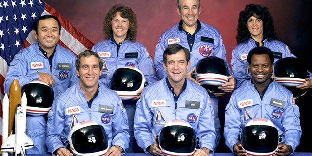An official portrait shows the STS-51L crewmembers. Back row (L to R): Mission Specialist, Ellison S. Onizuka, Teacher in Space Participant Sharon Christa McAuliffe, Payload Specialist, Greg Jarvis and Mission Specialist, Judy Resnik. Front row (L to R): Pilot Mike Smith, Commander, Dick Scobee and Mission Specialist, Ron McNair.