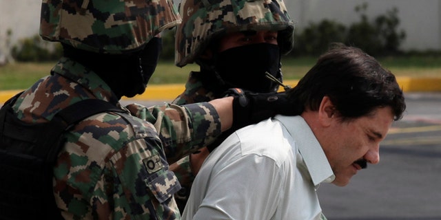 Joaquin "El Chapo" Guzman is escorted to a helicopter by Mexican navy marines in Mexico City, on Feb. 22, 2014.