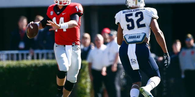 Georgia quarterback Hutson Mason (14) throws under pressure from Charleston Southern linebacker Gabe Middlebrook (52) in the first half of an NCAA college football game, Saturday, Nov. 22, 2014, in Athens, Ga. (AP Photo/John Bazemore)