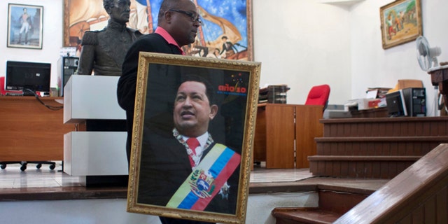 Dec. 21, 2012: Pierre Denis, who works at Venezuela's embassy, carries an image of Venezuela's President Hugo Chavez after holding a Mass to pray for Chavez's health in Petion-Ville, Haiti.