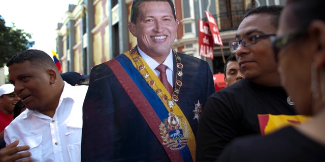 Jan. 10, 2013: In this file photo, supporters of Venezuela's President Hugo Chavez carry a life-size cut out image of him during a symbolic inauguration ceremony for Chavez, who was in Cuba for cancer treatment at the time, in Caracas, Venezuela.