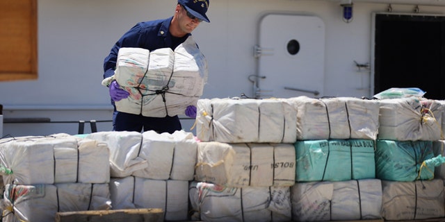 MIAMI, FL - APRIL 26: A crew member from the Coast Guard Cutter Bernard C. Webber piles up some of the 2,200 pounds of cocaine after it was seized during Operation Martillo, worth an estimated $27 million on April 26, 2013 in Miami, Florida. The cocaine was found while the crew was conducting a law enforcement patrol, where they located a 68-foot fishing vessel in the western Caribbean Sea, April 18, 2013. The crew of the Cutter Gallatin boarded the vessel, located 2,200 pounds of cocaine, and detained three suspected smugglers. (Photo by Joe Raedle/Getty Images)