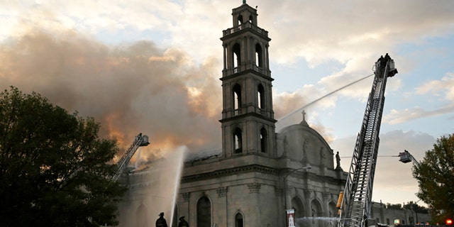 Chicago firefighters work at the scene of an extra-alarm fire at Shrine of Christ the King Church.