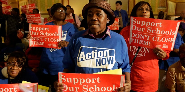 Protesters of Mayor Rahm Emmanuel's plan to close dozens of city schools rally in the rotunda at the Illinois State Capitol Wednesday, May 22, 2013 in Springfield Ill. The Chicago Board of Education was expected to take a final vote Wednesday on whether to close 53 schools. (AP Photo/Seth Perlman)