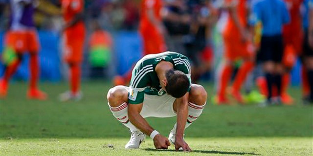Mexico's Javier Hernandez punches the ground after the Netherlands defeated Mexico 2-1 to advance to the quarterfinals during the World Cup round of 16 soccer match between the Netherlands and Mexico at the Arena Castelao in Fortaleza, Brazil, Sunday, June 29, 2014. (AP Photo/Eduardo Verdugo)