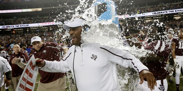 December 31, 2013: Texas A&M coach Kevin Sumlin is dunked in the closing seconds of a 52-48 win over Duke in the the Chick-fil-A Bowl in Atlanta. Shortly after taking this photo, Associated Press photographer Dave Martin collapsed of an apparent heart attack and was pronounced dead early Wednesday at an Atlanta hospital. (AP Photo/Dave Martin)