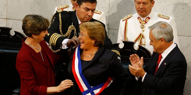 Bachelet receives the presidential sash from Senate President Isabel Allende, Tuesday, March 11, 2014.