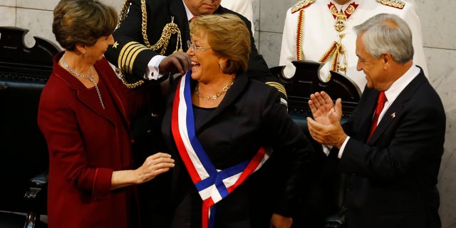 Bachelet receives the presidential sash from Senate President Isabel Allende, Tuesday, March 11, 2014.
