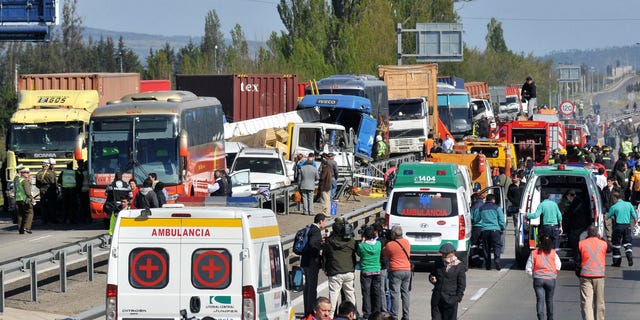 Emergency personnel gather at the scene of a multi-vehicle pile-up on a highway in Casablanca, about 43 miles or 70 kilometers from Santiago, Chile, Wednesday Oct. 12, 2011. According to government officials, at least four people died and 49 were injured.