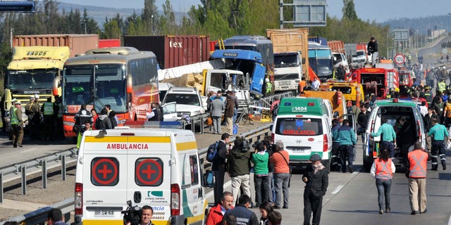 Emergency personnel gather at the scene of a multi-vehicle pile-up on a highway in Casablanca, about 43 miles or 70 kilometers from Santiago, Chile, Wednesday Oct. 12, 2011. According to government officials, at least four people died and 49 were injured.