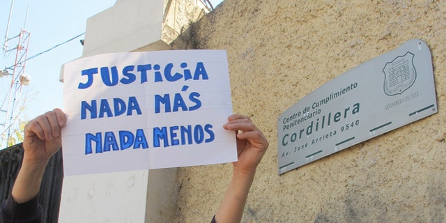 Claudio Escobar holds up a sign that reads in Spanish "Justice. Nothing more. Nothing less" at a demonstration organized by human rights activists outside the Cordillera prison in Santiago, Chile, Wednesday, Sept. 25, 2013. Chile's president announced Thursday that he will close the Cordillera prison, a luxury prison for dictatorship-era military officials convicted of crimes against humanity, taking away their tennis courts, barbecues and a pool. (AP Photo/Luis Andres Henao)