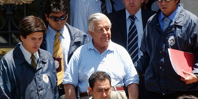 FILE.- In this Jan. 28, 2005 file photo retired Gen. Manuel Contreras, center, is escorted by police officers in Santiago, Chile. According to Chile's government, Contreras, the former chief of Chile's spy agency responsible for the kidnapping and torture of thousands during the Pinochet military dictatorship died Friday in Santiago's military hospital. He was 86.(AP Photo, File)