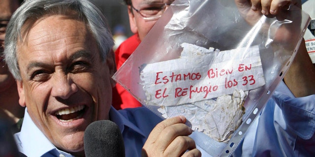 President Sebastian Pinera holds up a plastic bag containing a message,from miners trapped in a collapsed mine that reads in Spanish "We are ok in the refuge, the 33 miners" in Copiapo, Chile. (AP Photo/Hector Retamal, File)
