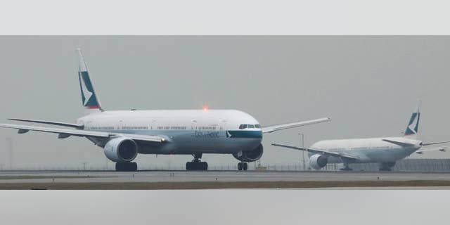 FILE - In this March 8, 2011 file photo, Cathay Pacific Airways planes queue up for departure at the Hong Kong Airport in Hong Kong. Chinese authorities say Cathay Pacific flight 831 from New York to Hong Kong was stranded for more than 16 hours in Zhuhai, China Sunday March 30, 2014 because of a hail storm and limits on the crew's work hours. (AP Photo/Kin Cheung)