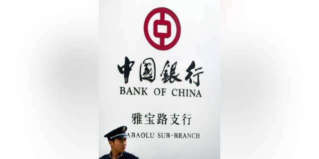 FILE - In this May 11, 2015 file photo, a security guard stands outside a Bank of China branch in Beijing. A New York judge has ordered the Bank of China to hand over detailed information about Chinese bank accounts used by a counterfeiting ring that allegedly sold millions of dollars of fake Gucci handbags and wallets in the U.S. (AP Photo/Mark Schiefelbein, File)