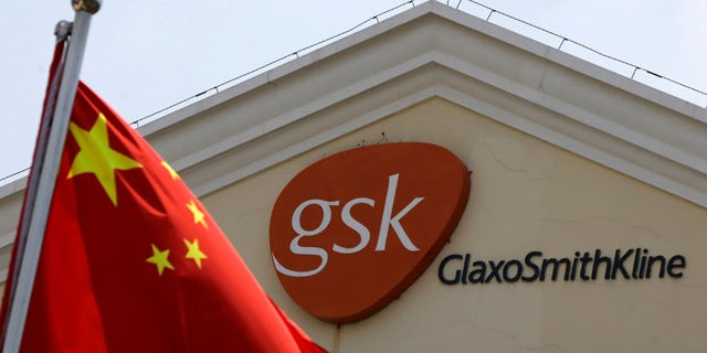 July 24, 2013: A Chinese flag is hoisted in front of a GlaxoSmithKline building in Shanghai, China. (AP Photo/Eugene Hoshiko, File)