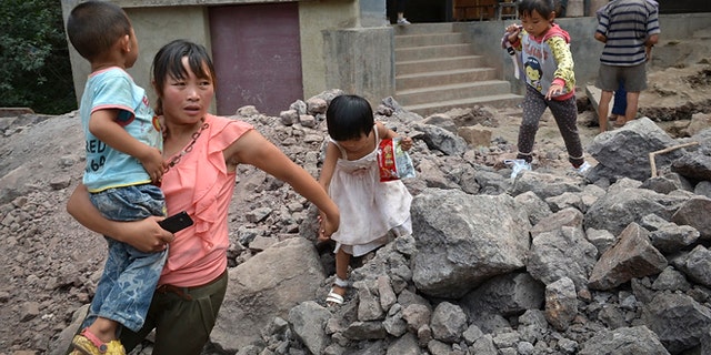 Sept. 8, 2012: A woman brings the children evacuate from an earthquake hit Luozehe town in Yiliang county in southwest China's Yunnan province.