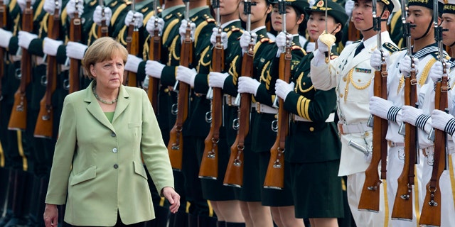 July 7, 2014: German Chancellor Angela Merkel reviews an honor guard during a welcome ceremony outside the Great Hall of the People in Beijing, China.(AP Photo/Andy Wong)