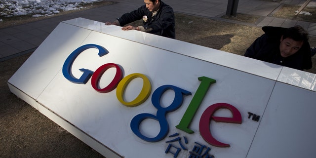 Workers repair a partially broken marble tablet which bears Google's logo in front of Google China's headquarters building in Beijing, China.