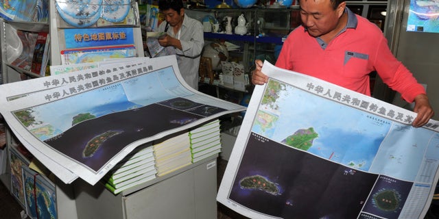 Sept. 19, 2012: In this photo, a costumer picks copies of newly-published maps of disputed islands, called Diaoyu in China and Senkaku in Japan, at a state-owned book store in Beijing, China.