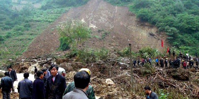 In this photo taken Thursday Oct. 4, 2012, residents gather at a landslide in Yiliang county in southwest China's Yunnan province. All 18 elementary school students buried in the landslide were confirmed dead Friday, while one other person remained missing a day after the hillside collapsed and smothered part of a village in mountainous southwestern China. (AP Photo) CHINA OUT