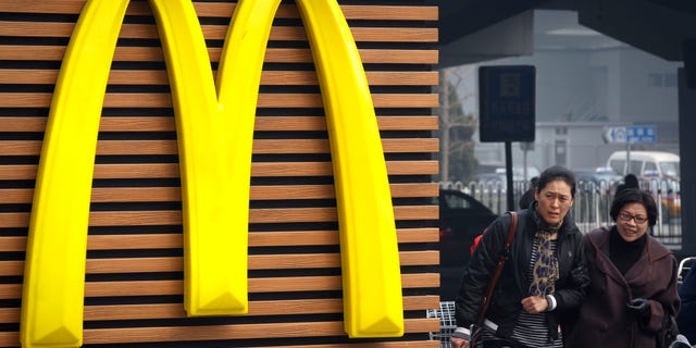 Mar. 16, 2012: Chinese women walk past a McDonald's sign in Beijing.