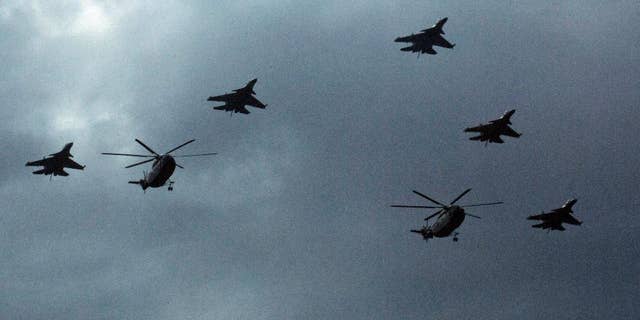 Chinese military helicopters and fighter jets take part in rehearsals ahead of the Sept. 3 military parade to commemorate the end of World War II in Beijing, Sunday, Aug. 23, 2015. China is ramping up publicity for its upcoming massive military parade but officials still aren't saying what other countries are taking part. (AP Photo/Ng Han Guan)
