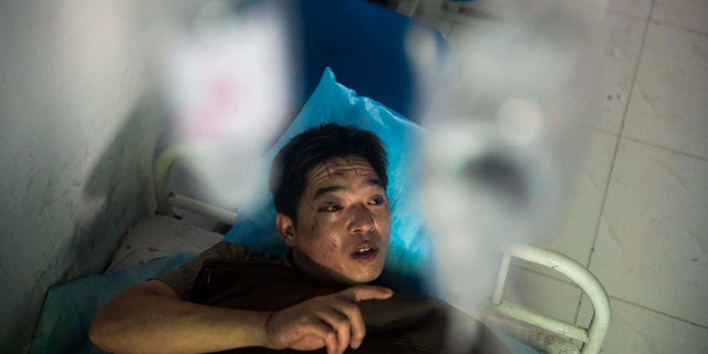 July 6, 2014: In this photo released by China's Xinhua News Agency, miner Duan Xukang receives a treatment at a hospital in Fukang City, northwest China's Xinjiang Uygur Autonomous Region, after being rescued following a gas explosion at a coal mine. (AP Photo/Xinhua, Jiang Wenyao)