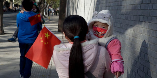 Nov. 16. 2013: Visitors to the forbidden city carry children holding the Chinese national flags in Beijing, China.